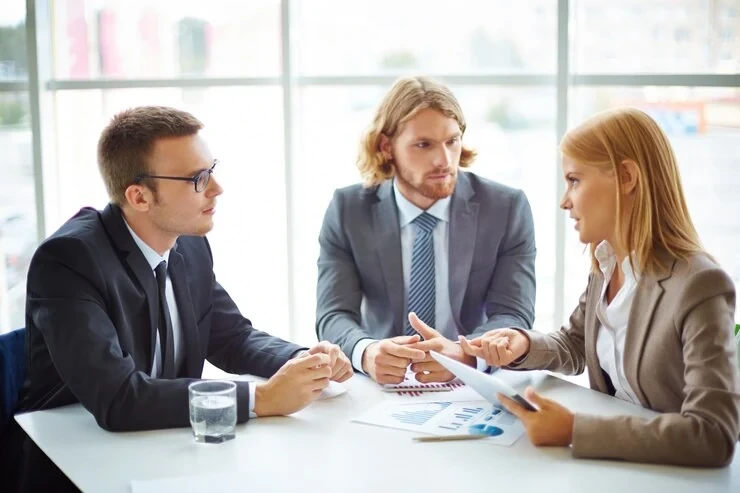 Three professionals discussing business strategy