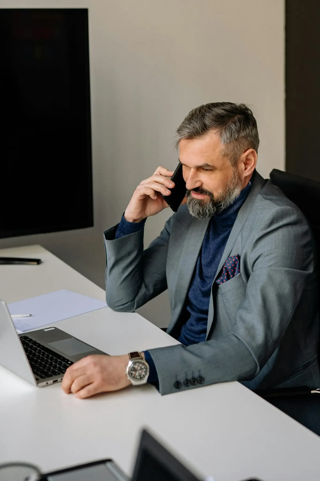 Executive on phone call working at laptop